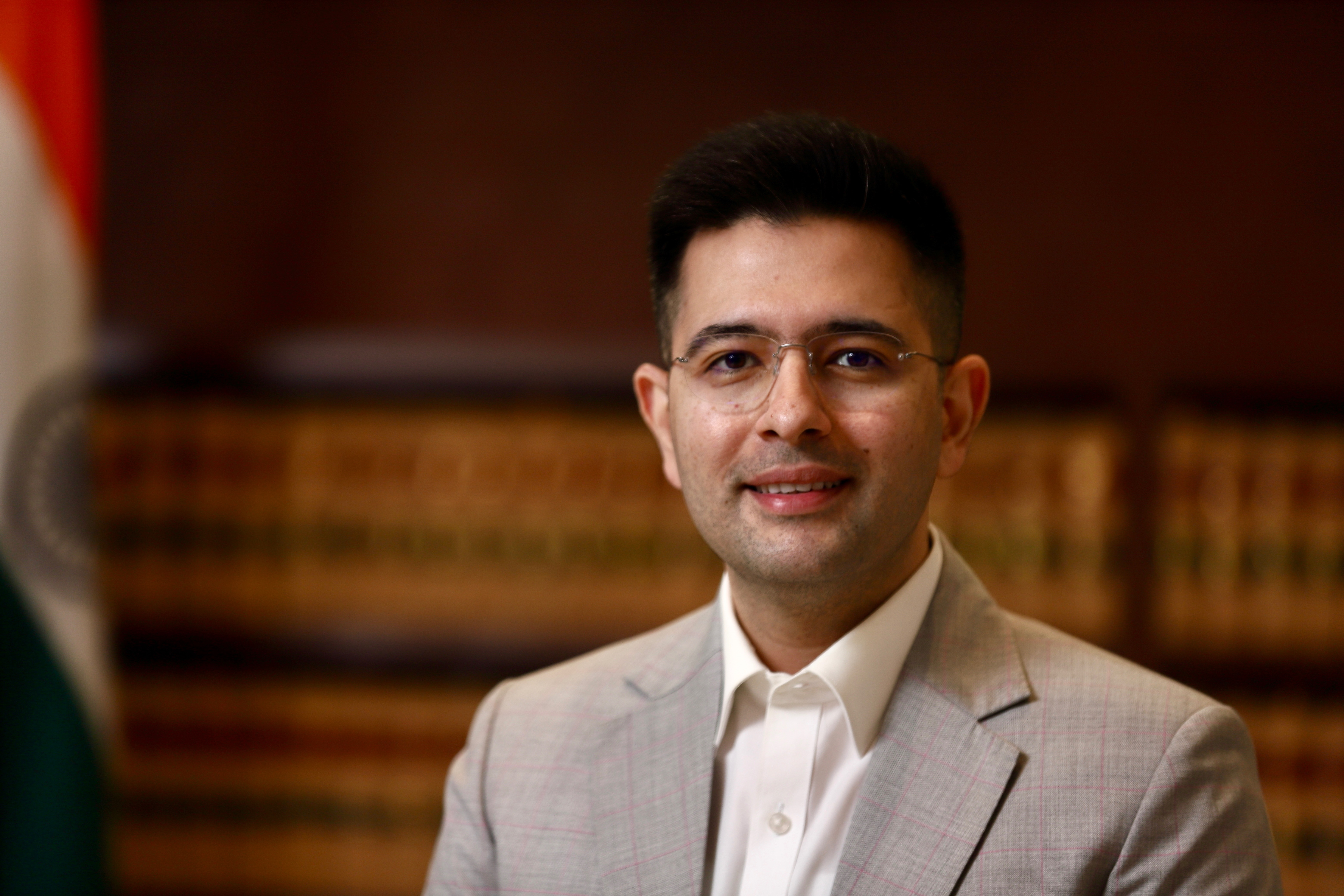 Raghav Chadha in light suit with Indian flag background